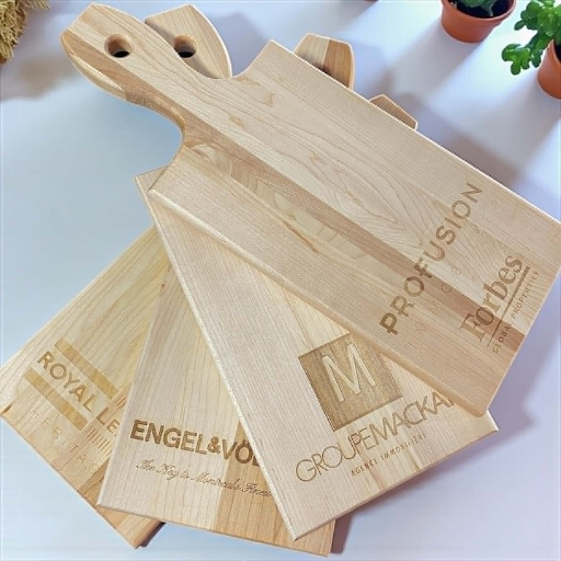 Small maple paddle boards engraved with Montréal brokerage crests